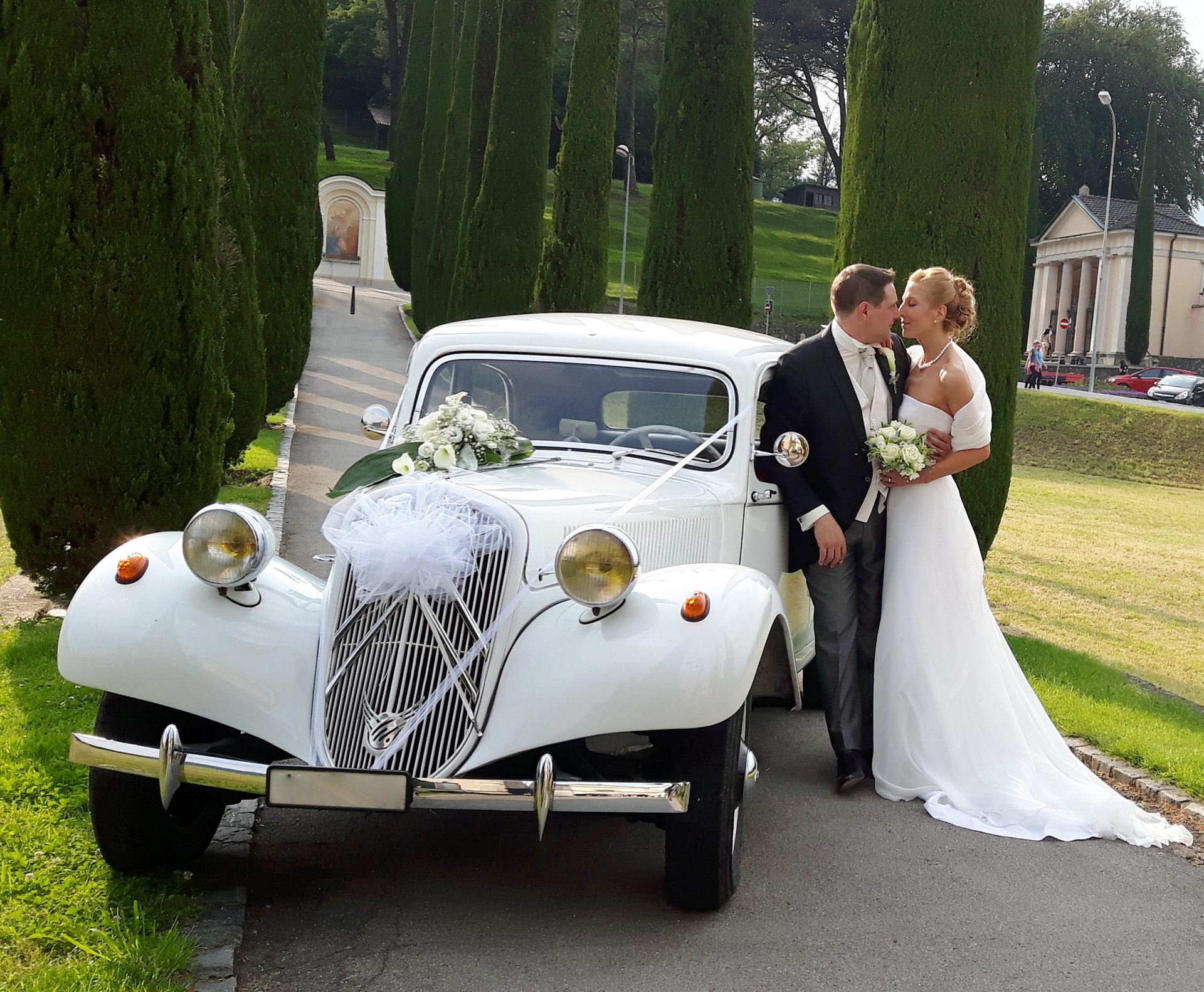 Sposi accanto alla Traction Avant lungo un viale di cipressi