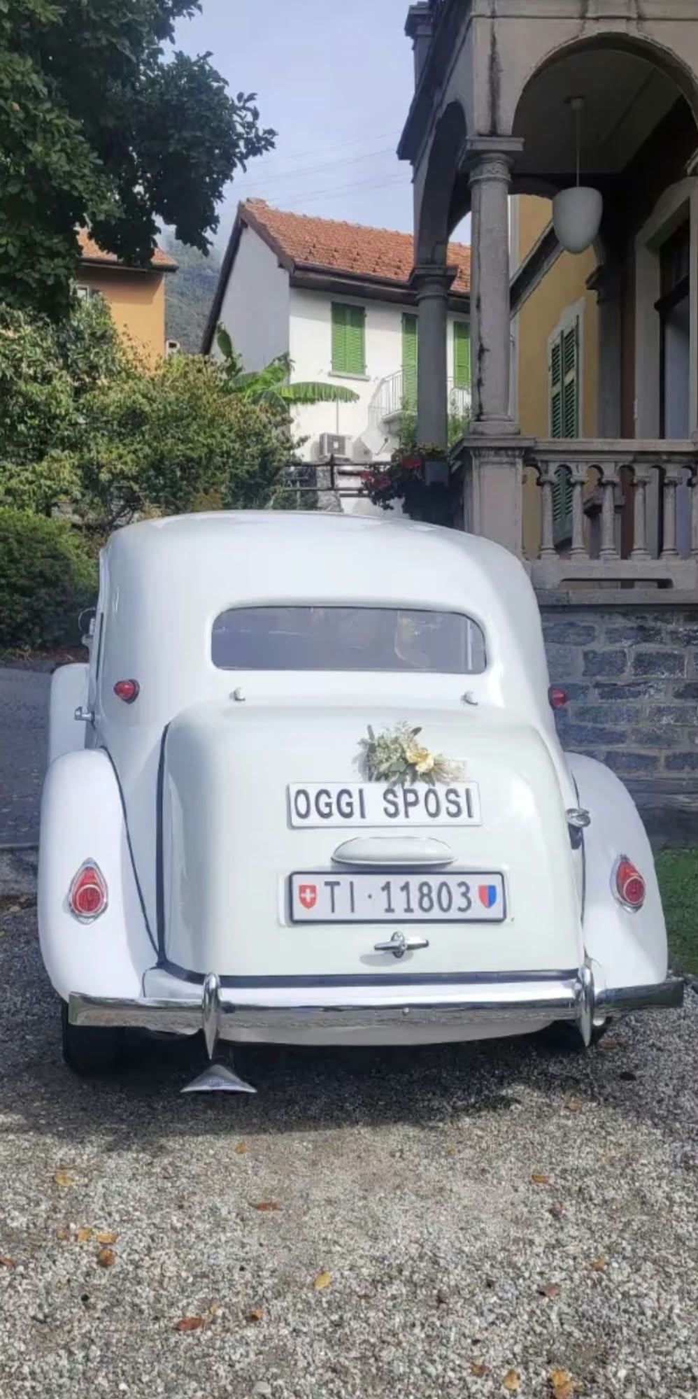 Il cartello «Oggi sposi» e la targa sul retro della vettura, davanti a una villa