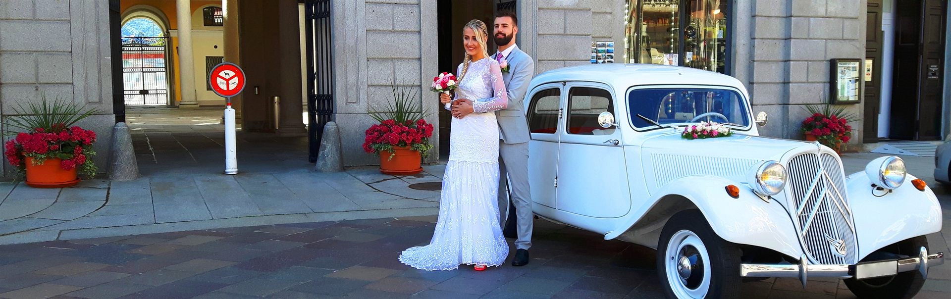 La vettura bianca con gli sposi sotto i portici, in una piazza ticinese